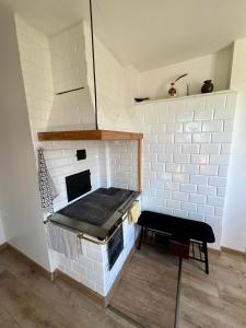 a white brick oven with a bench in a room at Biebrzańskie Zacisze in Goniadz
