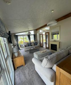 sala de estar con sofá y chimenea en Bluebell Luxury 2 Bedroom Lodge at Southview Holiday Park, en Skegness