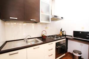 cocina con fregadero y microondas en Apartments Tomi & Ivana, en Trogir