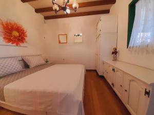 Un dormitorio con una gran cama blanca y una ventana en Apartments Tomi & Ivana, en Trogir