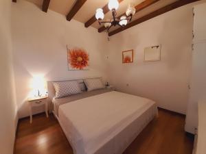 1 dormitorio con 1 cama blanca y 1 lámpara en Apartments Tomi & Ivana, en Trogir