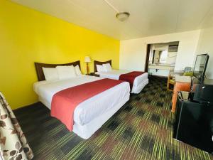 two beds in a hotel room with yellow walls at Quality Lodge in Sandusky