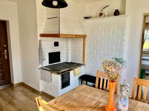 uma cozinha com um forno de tijolo e uma mesa de madeira em Biebrzańskie Zacisze em Goniadz