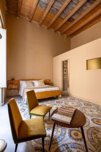 a bedroom with a bed and a table and chairs at Palazzo Sant'Isidoro by DomuSicily in Palermo