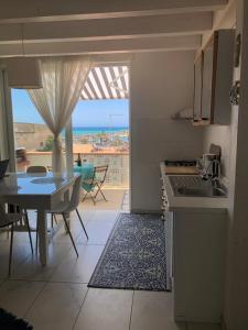 eine Küche und ein Esszimmer mit Meerblick in der Unterkunft Le Muse casa vacanze in Scoglitti