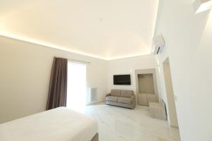 a white room with a bed and a couch at Principe Boemondo Luxury Room in Canosa di Puglia +64 photos