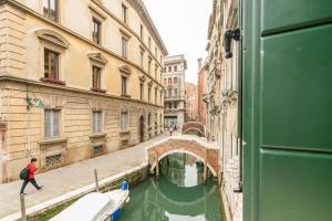 a canal in a city with a bridge and buildings at Cinqueteste Luxury Home in Venice