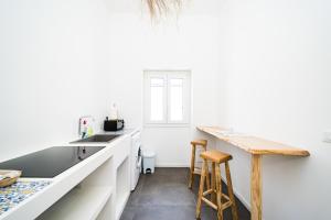a kitchen with white cabinets and a counter with stools at Salento Boutique Suite in Sant'Isidoro