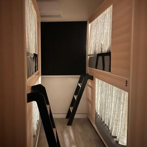 a room with a bunk bed and two windows at Luxury Hostel in Riyadh