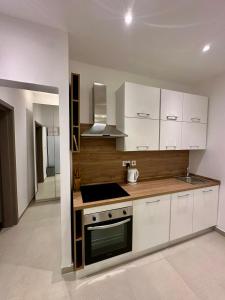 a kitchen with white cabinets and a stove top oven at Acacia Avenue Apartments in Is-Swieqi