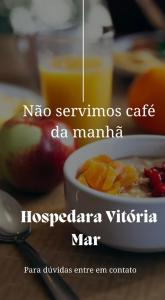 uma tigela de mingau de aveia com frutas e uma xícara de suco em Hospedaria Vitória Mar em Ubatuba