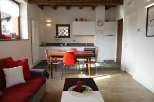 a living room with a red couch and a table at Cjase Dai Fornasirs 2 in Raveo