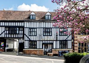 an old black and white building with a flowering tree at White Hart Hotel in St. Albans
