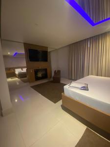 a hotel room with a bed and a tv at Motel My Flowers 4 in Sao Paulo