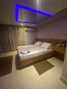 a bedroom with a large bed with a blue light at Motel My Flowers 4 in Sao Paulo
