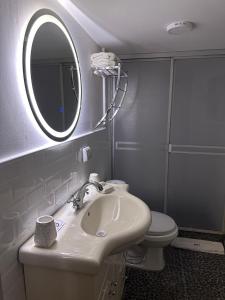 La salle de bains est pourvue d'un lavabo, d'un miroir et de toilettes. dans l'établissement Blacky Hostel and Apartments, à Cusco