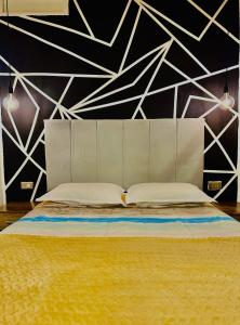 um quarto com uma cama com uma parede em preto e branco em Blacky Hostel and Apartments em Cusco