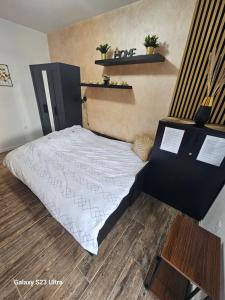 ein Schlafzimmer mit einem Bett mit einer weißen Bettdecke in der Unterkunft Apartman Lena in Zrenjanin