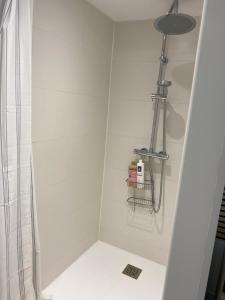 a white bathroom with a shower and a light at Dune et Terrasse in Merville-Franceville-Plage +45 photos