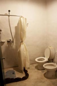 a bathroom with a toilet and a shower curtain at Postales del Tiempo in Tilcara