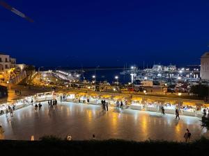 a group of people walking around a plaza at night at Una finestra sul mare in Bari