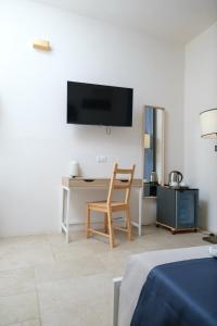 a room with a desk and a chair and a tv at Masseria Borgo Santuri in Ostuni