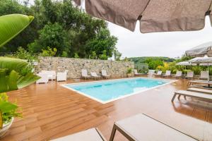 einen Pool auf einer Terrasse mit Stühlen und einem Tisch in der Unterkunft Olia Suites Parga in Parga