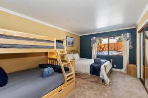 Un dormitorio con dos literas y una ventana. en Oak Pines Lodge W Spa & fenced backyard, en Big Bear Lake