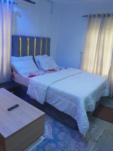 a bedroom with two beds and a table at Sammy's Place in Lekki