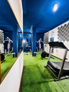 un gimnasio con paredes azules y alfombra verde en Hotel Metropolitano en Loja