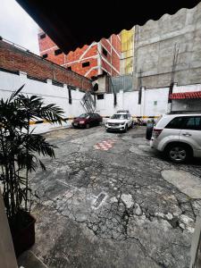 un estacionamiento con autos estacionados frente a un edificio en Hotel Metropolitano en Loja