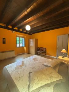 Zubieta的住宿－Zubietako Ostatua，橙色墙壁的客房内的一张大床