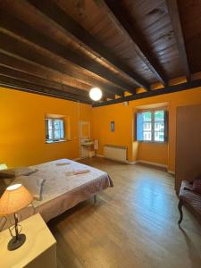 a bedroom with a large bed and yellow walls at Zubietako Ostatua in Zubieta