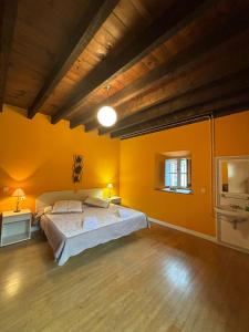 Zubietako Ostatua في Zubieta: غرفة نوم كبيرة بجدران صفراء وسرير كبير