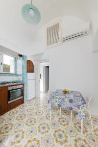 a living room with a table and a kitchen at Il Merlo Capri in Capri