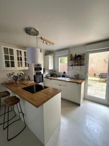 a kitchen with white cabinets and a large window at Maison Stade de France in Saint-Denis