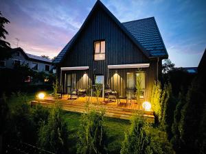 a house with a wooden deck in the yard at G17-1 Palanga in Palanga