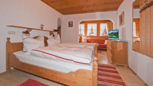 a bedroom with a bed and a television in it at Ferienwohnungen Weiß in Mittenwald