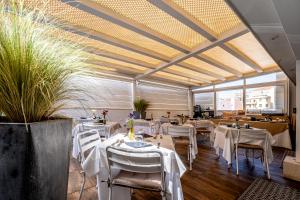 a restaurant with white tables and chairs and windows at Neko Boutique Hotel in Cagliari