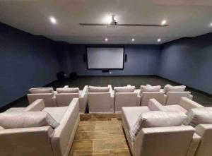ein Kinoraum mit weißen Sofas und einer Leinwand in der Unterkunft Brand New Luxury 1 BDR Pool-Cine - Saune-WIFI - I 19 in Santo Domingo + 40 Fotos