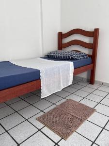 a bedroom with a bed with a blue mattress and a rug at Morada dos Colibris in Natal