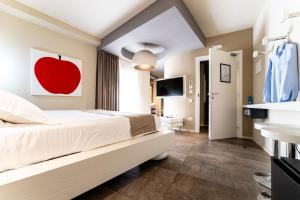 a bedroom with a bed with a red apple painting on the wall at Neko Boutique Hotel in Cagliari