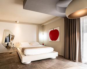 a bedroom with a bed and an apple painting on the wall at Neko Boutique Hotel in Cagliari