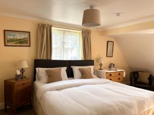 Un dormitorio con una cama grande y una ventana en The Cottage Guest House en Bishops Stortford