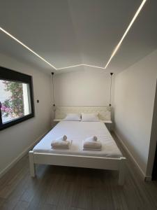 a white bed in a room with a window at Villa paradise in Podstrana