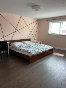 a bedroom with a bed with a geometric wall at KenHouse in Toronto