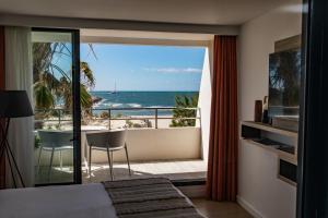 a bedroom with a balcony with a view of the ocean at Hôtel La Plage 5 étoiles La Grande Motte in La Grande-Motte