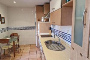 a small kitchen with a sink and a table at Galia Ballena (Rota) - Carlos in Costa Ballena