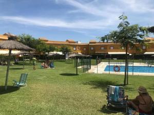 a woman sitting in a stroller next to a swimming pool at Galia Ballena (Rota) - Carlos in Costa Ballena