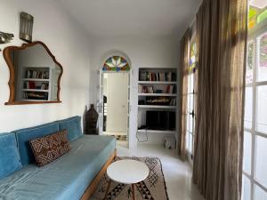ein Wohnzimmer mit einem blauen Sofa und einem Tisch in der Unterkunft casabonita in Asilah